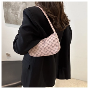Detail of pink monogram crescent hobo bag shown on model wearing black blazer