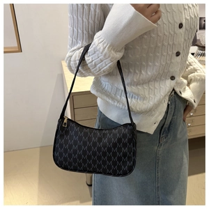 Close-up of minimalist black crescent shoulder bag with grey M letter jacquard pattern