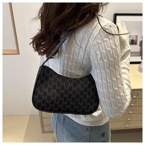 Chic black crescent underarm bag with all-over M monogram pattern worn by a model