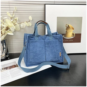Close-up of Morandi blue corduroy tote bag with side fashion label and front pockets