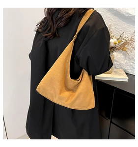 Modello con grande borsa hobo in pelle scamosciata gialla in un interno minimale