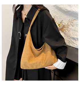 Dettaglio borsa tote in pelle opaca senape con trama scamosciata morbida e tracolla spalla