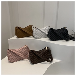 Close-up of five colorful M-pattern hobo bags with metallic zipper details on white stairs