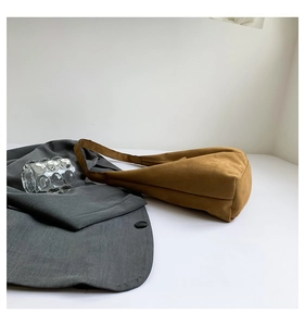 Dettaglio borsa hobo in pelle scamosciata marrone con texture opaca e tracolla larga