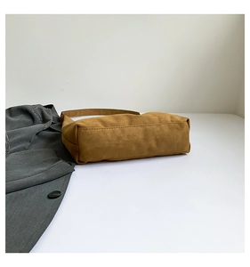 Dettaglio borsa tote in pelle scamosciata marrone con tracolla dal design retrò