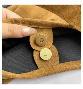 Dettaglio della fibbia magnetica dorata sulla borsa tote in pelle scamosciata marrone