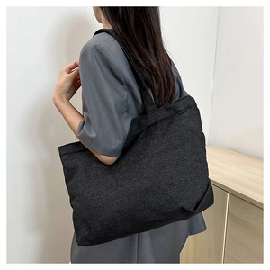 Detailed side view of a large dark grey denim tote bag showing its spacious capacity and fabric