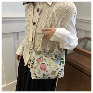 Detail of floral tote bag with adjustable shoulder strap and embroidery patterns