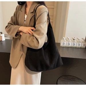 Minimalist black oversized hobo bag in soft suede styled with an elegant casual outfit