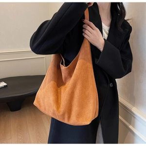 Close-up of caramel suede tote bag shown on a model for everyday casual fashion style