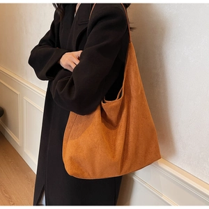Detailed view of spacious caramel suede tote bag shown on model with chic minimal styling