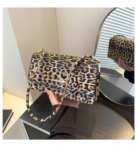 Détail du sac sous l'aisselle à imprimé léopard avec un fermoir en métal doré minimaliste