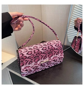 Détail d'un sac à bandoulière rose léopard avec boucle dorée et cuir synthétique texturé