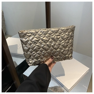 Detailweergave van de champagnegouden satijnen cosmetische tas met hartstiksel en rits