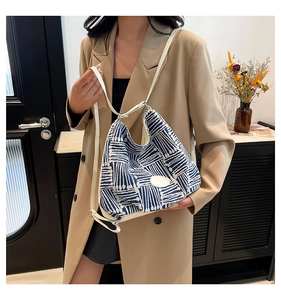 Chic blue and white striped canvas tote bag shown styled on a shoulder in a modern room