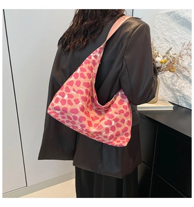 Vista dettagliata della borsa tote leopardata rosa indossata con giacca in pelle nera