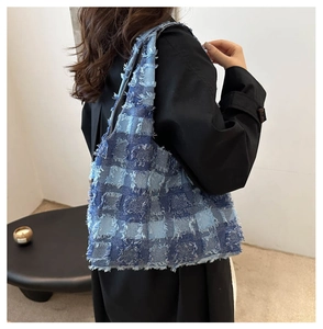 Detailansicht der Denim-Schachbrett-Tragetasche mit Fransen am Modedesign für Damen