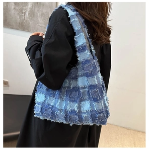 Detail der blauen Denim-Patchwork-Tasche mit ausgefransten Kanten und Design