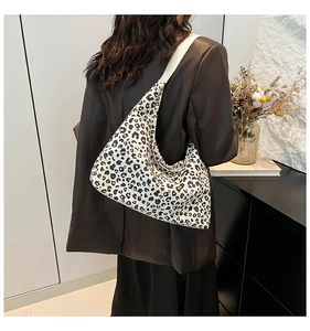 Borsa a spalla chic con stampa leopardata indossata con un blazer marrone in interni