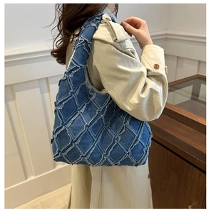 Detailansicht der Hobo-Tasche aus Denim mit ausgefransten Kanten, getragen von einem Model