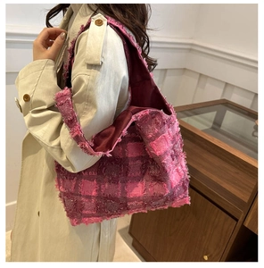 Nahaufnahme der rosa Tweed-Tasche mit Fransenkanten und burgunderrotem Innenfutter