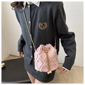 Dettaglio borsa a secchiello in denim rosa con motivo a rombi sfrangiati e accenti di perle