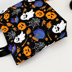 Dettaglio ravvicinato di tessuto con vivaci stampe di zucche e fantasmi di Halloween