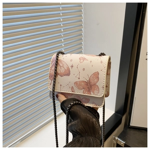 Détail du sac bandoulière crème avec motifs vintage de papillons et constellations