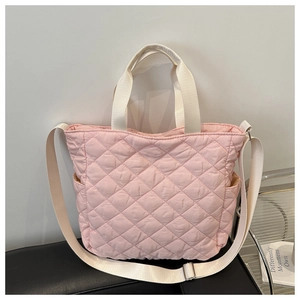 Detailed view of pink quilted tote bag with lattice stitching and nylon side pocket