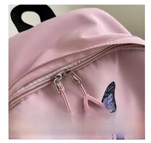 Close-up of smooth pink backpack zipper with purple butterfly prints and nylon texture