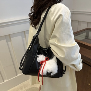 Minimalist black PU leather tote bag with a cute white puppy plush charm and red ribbon