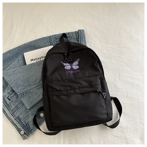 Close-up of black school backpack featuring purple butterfly print and Dreams slogan