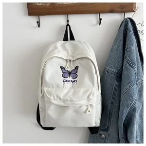 Detail of white nylon backpack featuring purple butterfly print and triangle zipper pull