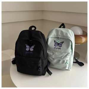Detail of cute school backpacks with butterfly and DREAMS print in black and mint green