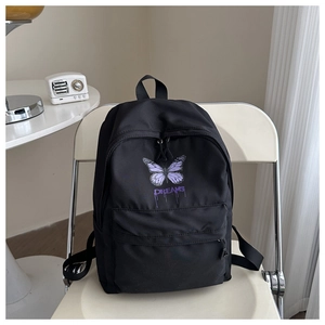 Close-up of black backpack featuring purple butterfly print and DREAMS artistic lettering
