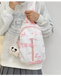 Detalle del bolso bandolera tie-dye con estampado de paisaje rosa y colgante de panda