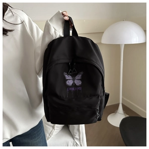 Close-up of black school backpack with purple butterfly print and Dreams text detail