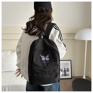 Detail of black backpack with purple butterfly print and DREAMS text on water-repellent fabric