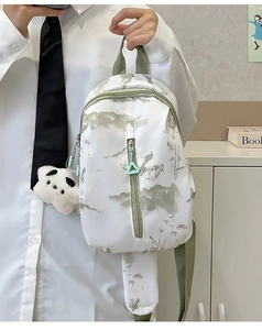 Detalle de bolso bandolera blanco tie-dye con estampados de bambú y dije de panda