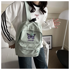 Detail of mint green school backpack featuring purple butterfly and Dreams print