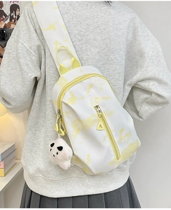 Detalle del bolso bandolera tie-dye amarillo con lindo colgante de peluche de panda
