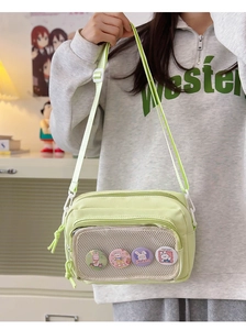 Detail of lime green mini messenger bag with mesh pocket and cute decorative badges