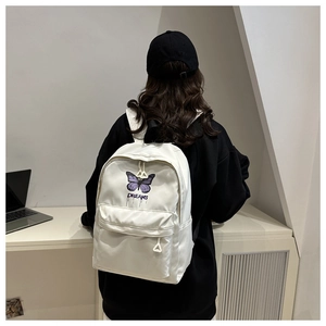 Detail of white butterfly backpack with Dreams print and unique triangle zipper pulls