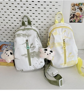 Primer plano de bolsos cruzados tie-dye con estampados de paisajes y dijes de estrellas
