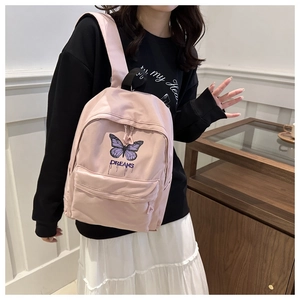 Detail of pink backpack featuring purple butterfly print and Dreams text design