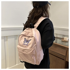 Close-up of pink school backpack with purple butterfly embroidery and Dreams lettering