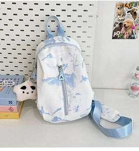 Detalle de mini mochila tie-dye con estampado de paisaje azul y colgante de panda
