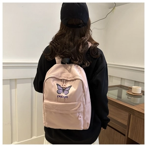 Close-up of pink school backpack featuring purple butterfly print and letter A zipper