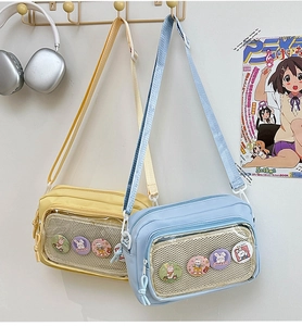 Detail view of Japanese style transparent crossbody bags in blue and yellow with cute badges