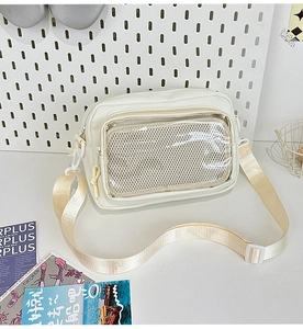Detail of cream-white canvas crossbody bag with clear PVC front window and zipper pocket